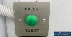 Stainless steel press to exit button mounted on a wall