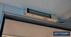 Magnetic lock fitted to the top of a door frame