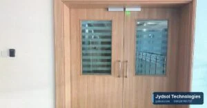 Wooden double doors with a card reader on the wall beside them